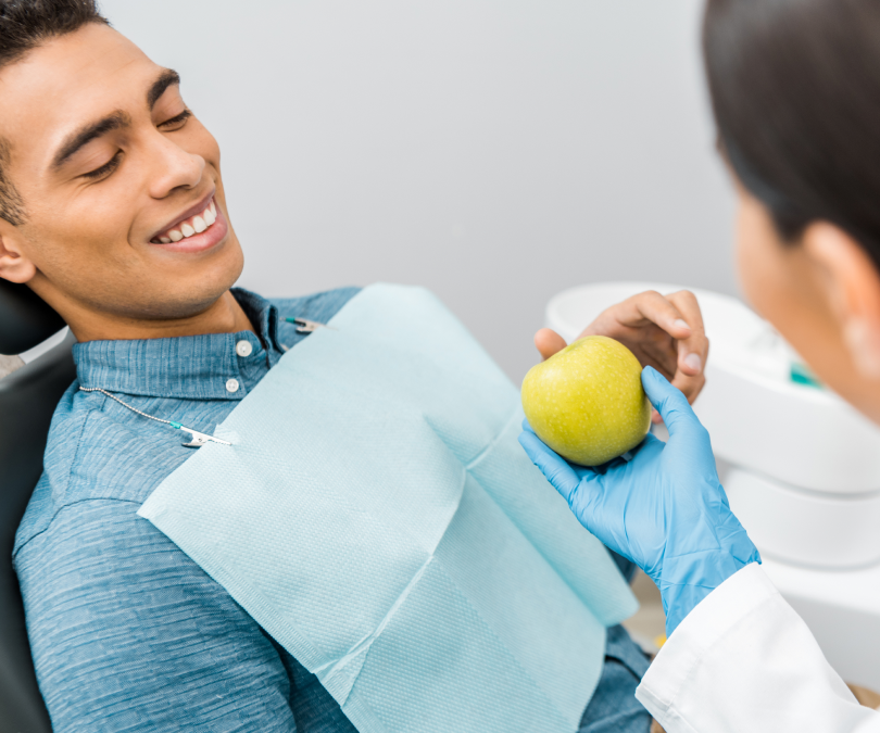 A young man receiving oral healthcare guidance from a dentist, similar to the holistic, education-focused experience provided when someone receives dental crowns in Burnaby at VCCID