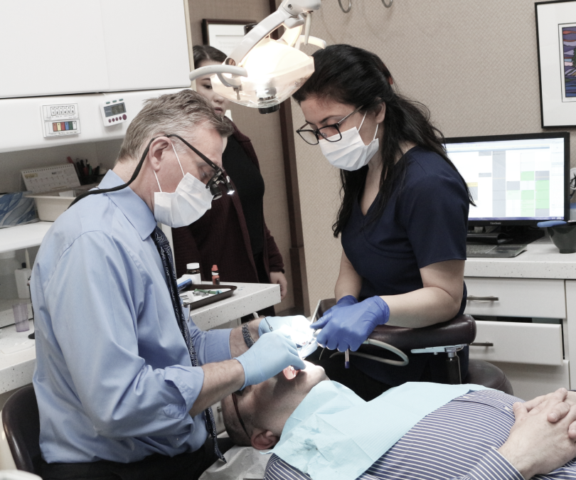 Burnaby Dentist Dr. Peter Balogh carefully treating a patient as he would for dental crowns in Burnaby or any other dental treatment